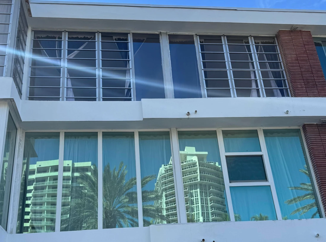 Before and after: original jalousie louvers above, new impact windows below