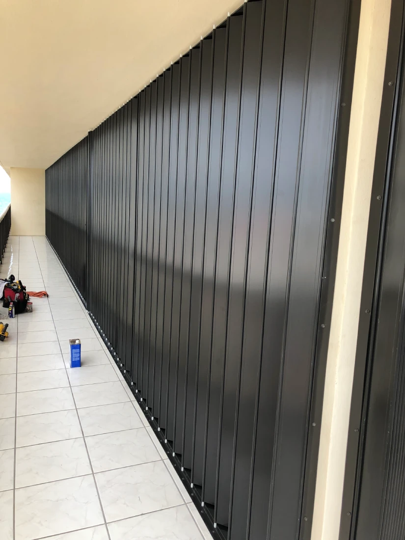 Completed accordion hurricane shutter on a condo balcony
